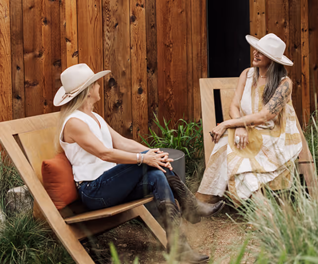 Two women in conversation, representing the hospitality and development work behind Frame Hospitality Group