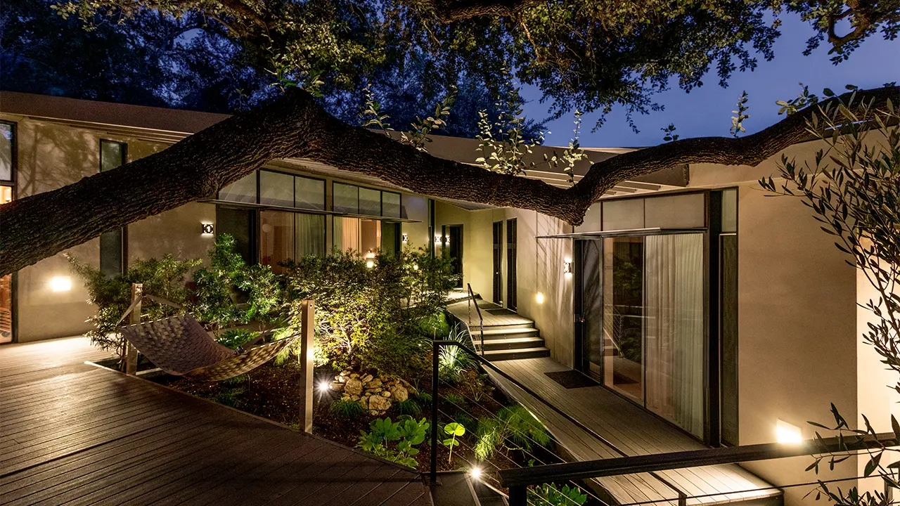 Treehouse deck at night opening toward the garden